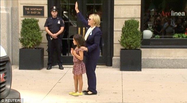 
B&agrave; Clinton &ocirc;m một đứa trẻ tr&ecirc;n đường khi đang bệnh. Ảnh: Reuters
