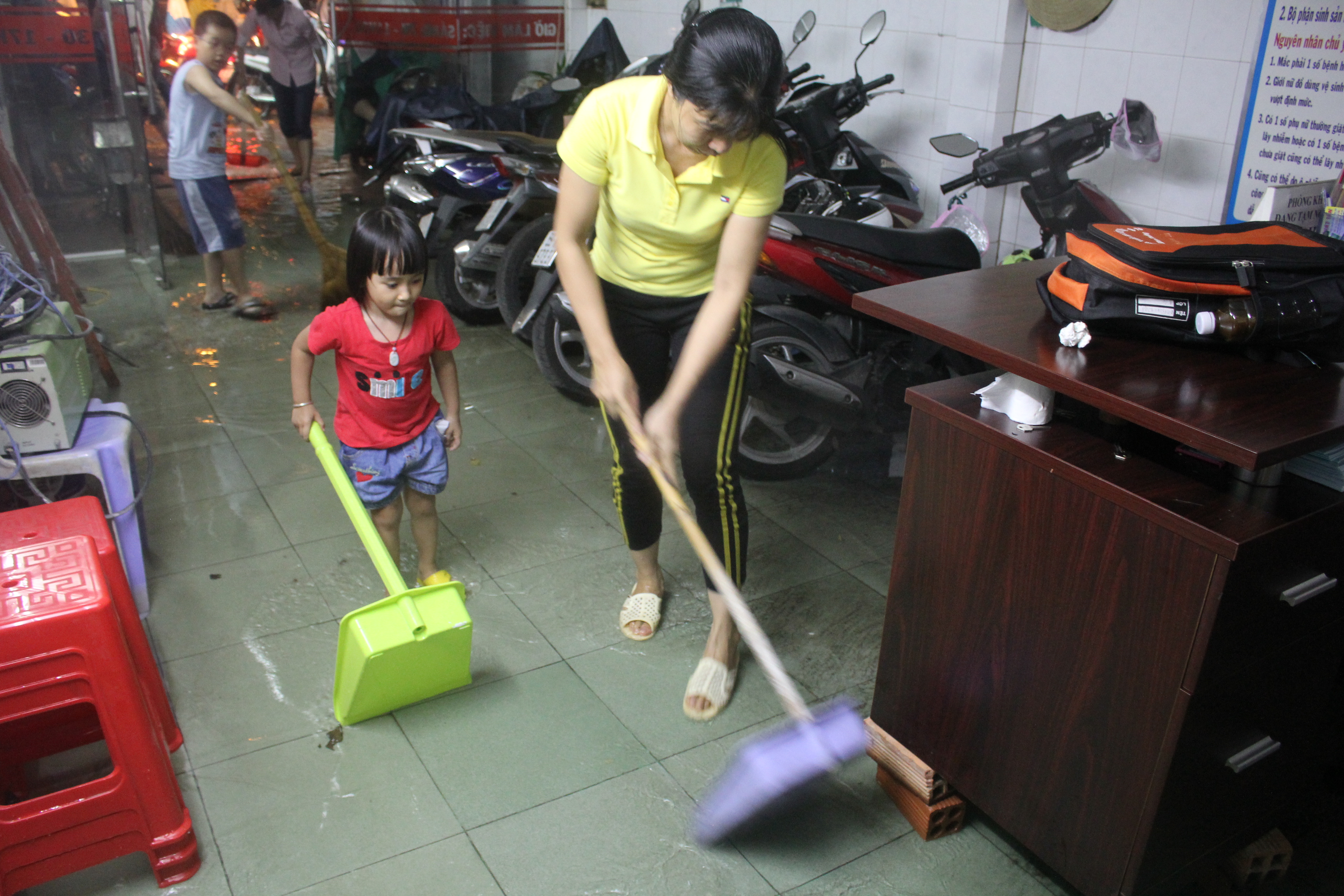 Cả gia đình cùng lao động hăng say do nước ngập vào nhà
