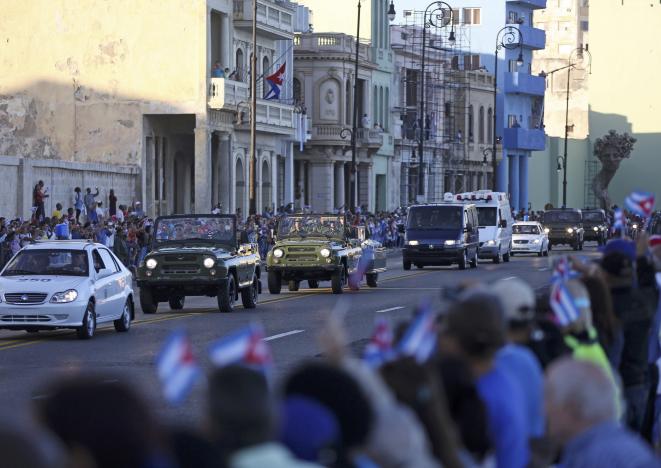 Người dân Cuba chụp hình và quay video đoàn xe. Ảnh: REUTERS