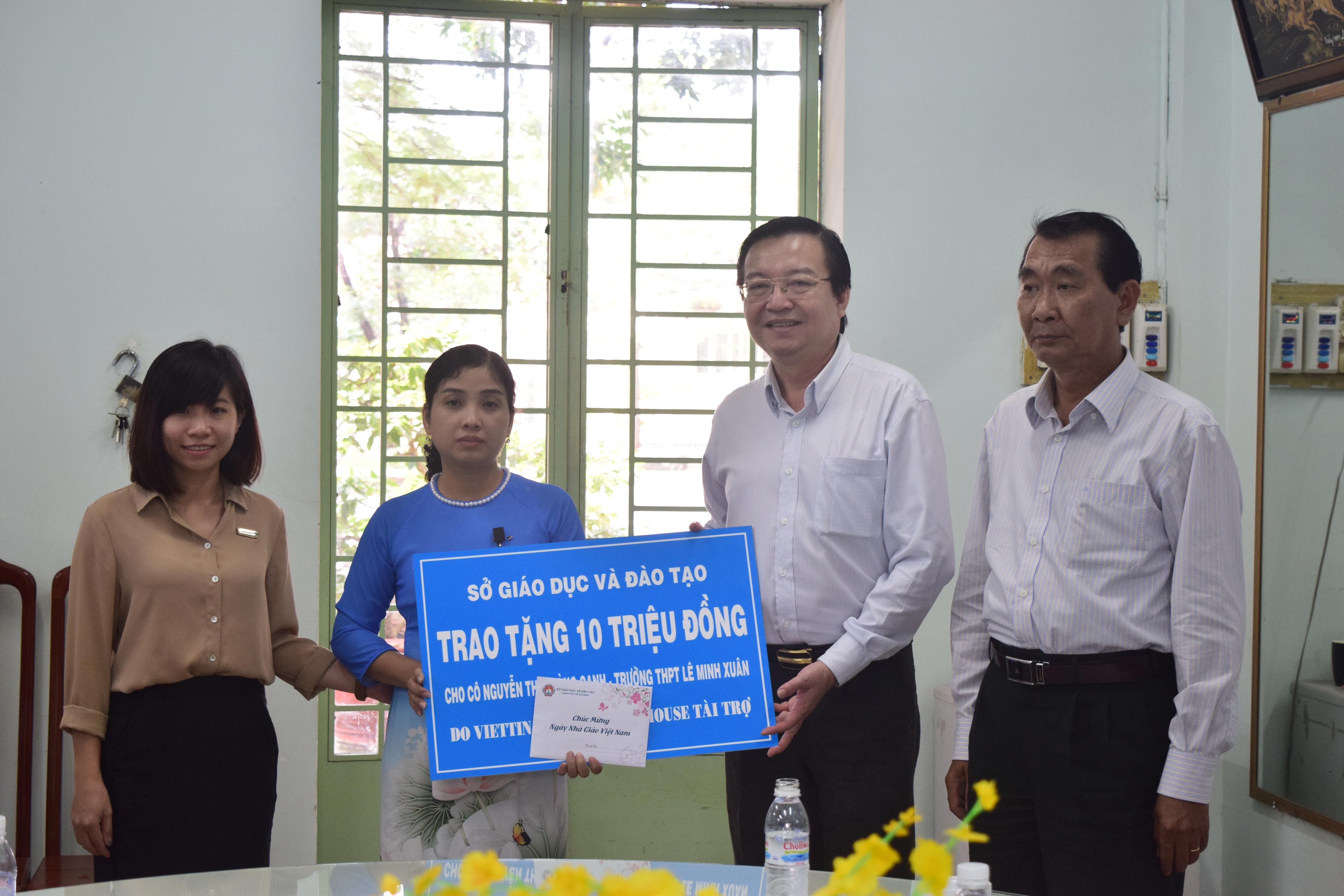 
&Ocirc;ng L&ecirc; Hồng Sơn (thứ hai từ phải qua), Gi&aacute;m đốc Sở GD-ĐT TP HCM, tặng qu&agrave; cho c&ocirc; Nguyễn Thị Ho&agrave;ng Oanh
