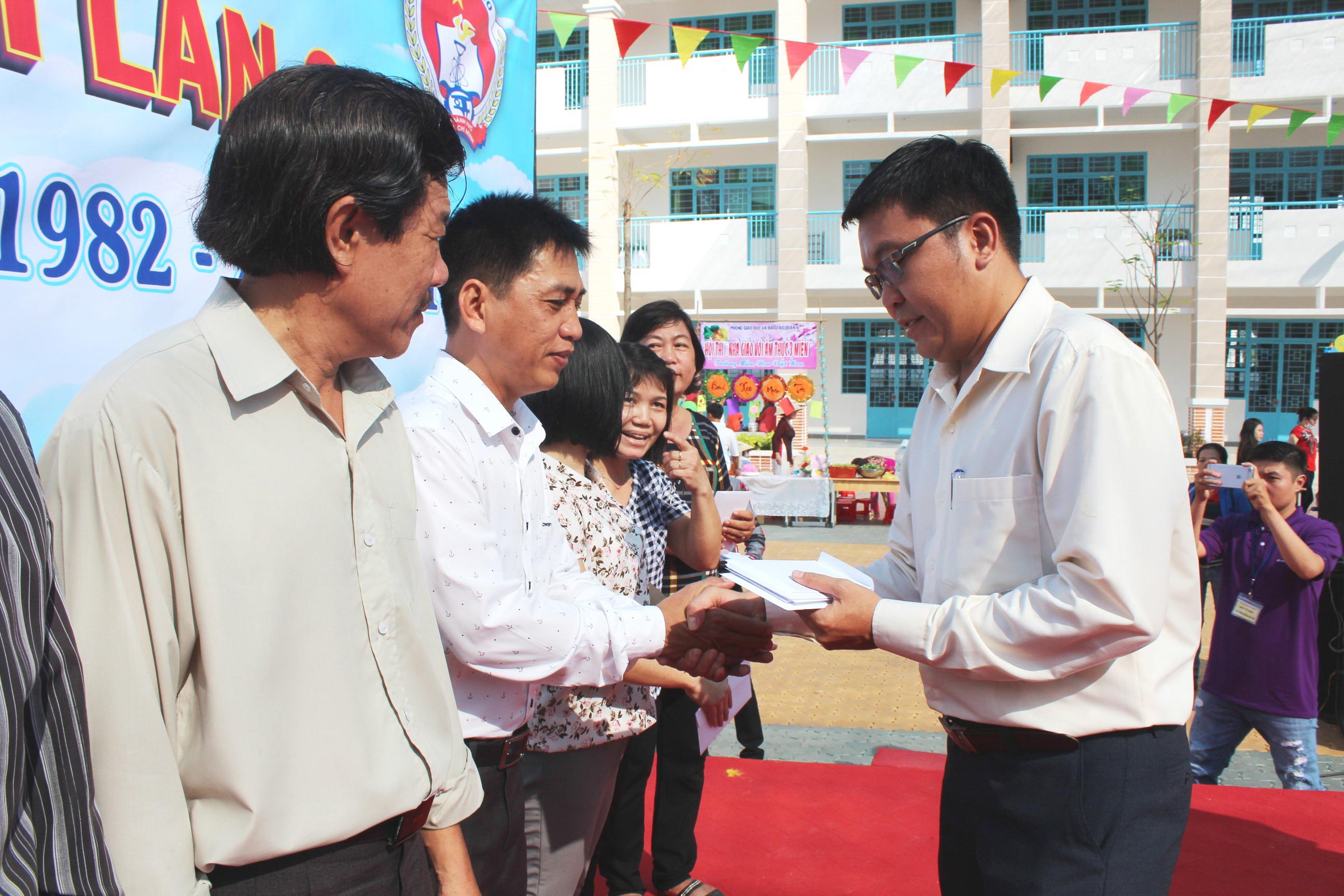 &Ocirc;ng Nguyễn Vũ Hạnh Ph&uacute;c - Ph&oacute; Chủ tịch LĐLĐ quận 8, TP HCM - trao tiền hỗ trợ cho gi&aacute;o vi&ecirc;n kh&oacute; khăn