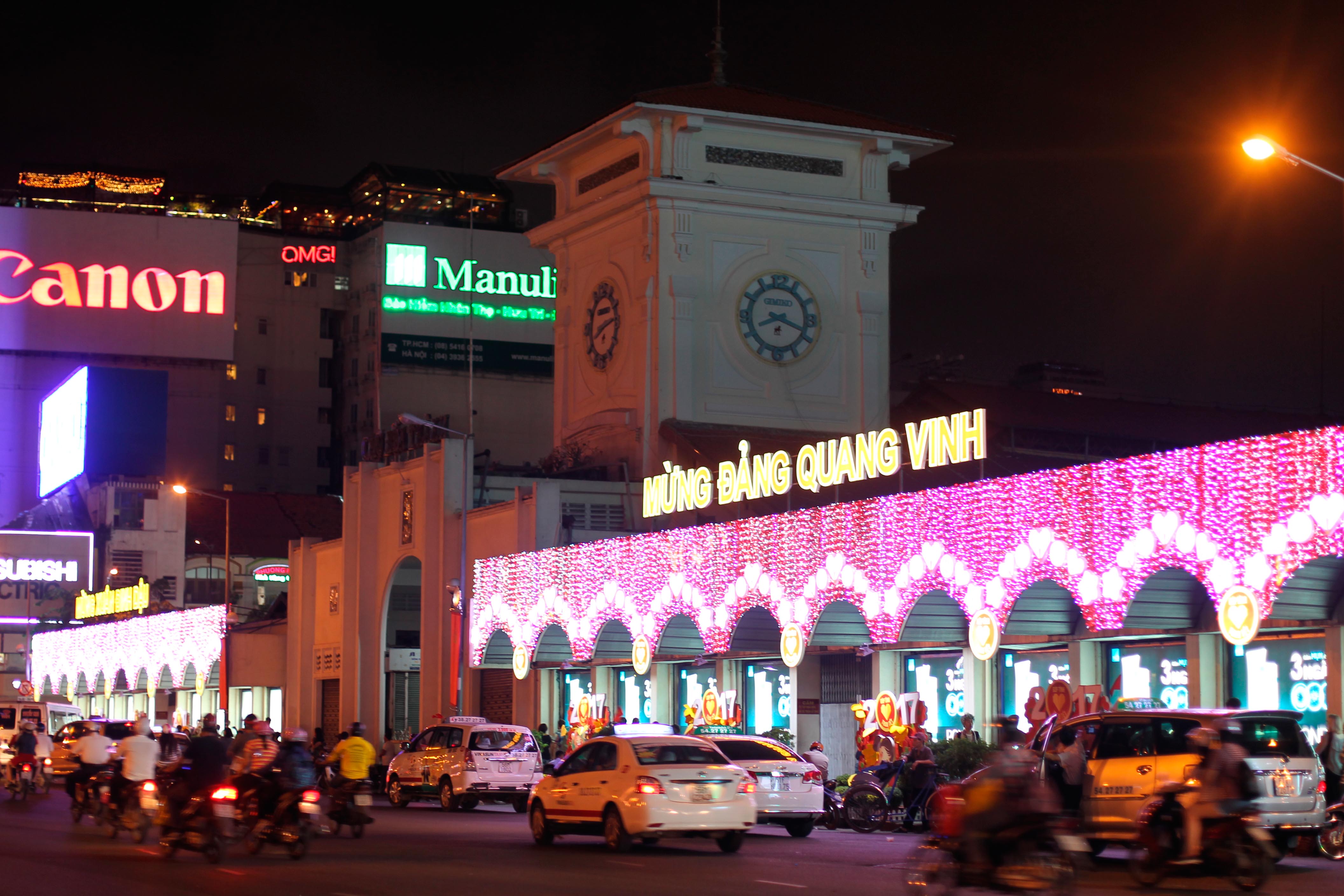 Cổng chợ Bến Thành được trang trí rực rỡ đón năm mới. Tuy nhiên, so với mọi năm thì trang trí khá đơn giản