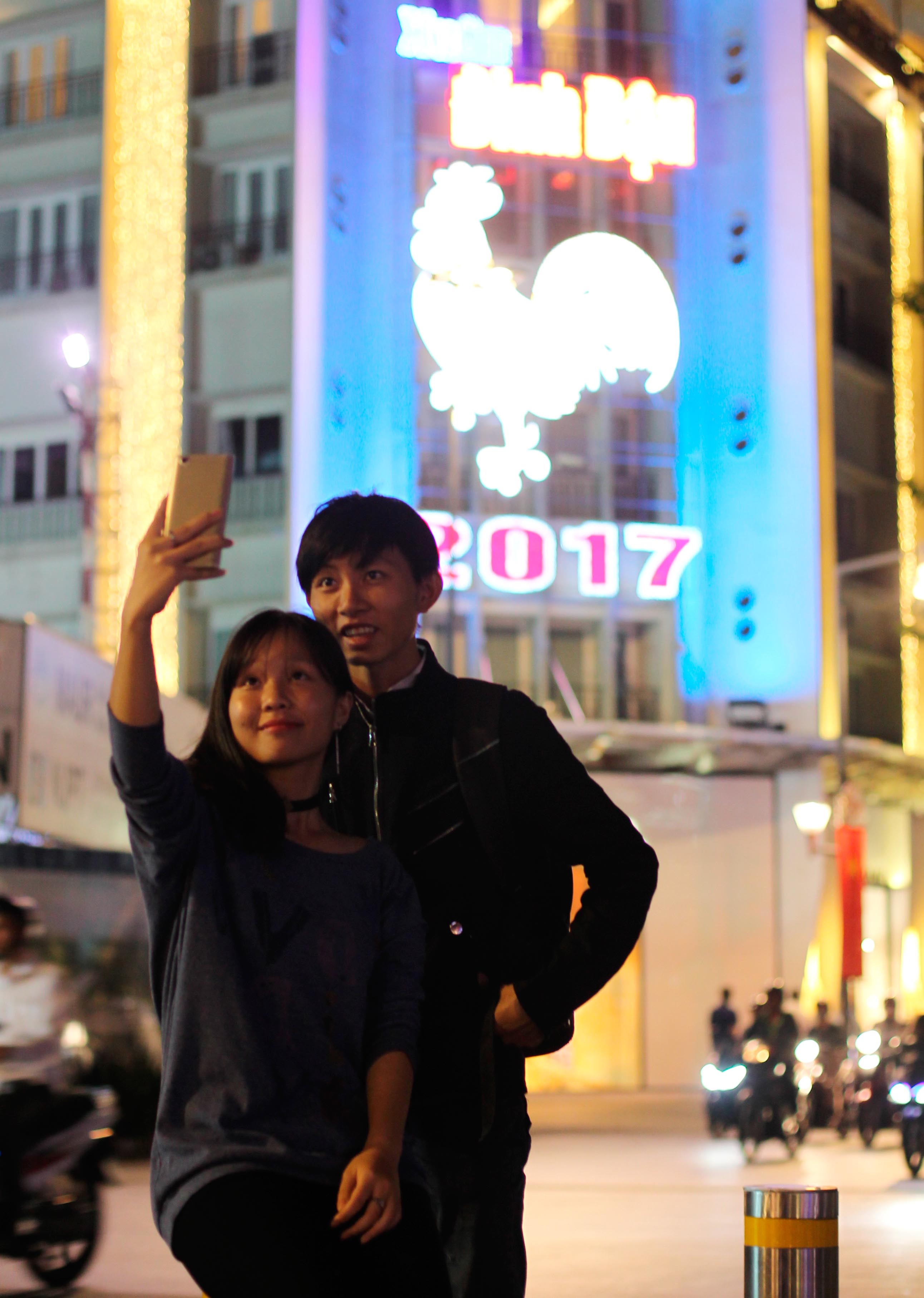 Hai bạn trẻ selfie trước hình ảnh đèn led hình biểu tượng năm Đinh Dậu trên phố đi bộ Nguyễn Huệ