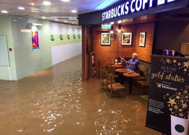 Hồng Kông phát cuồng vì cụ ông ngồi quán cafe giữa nước lụt