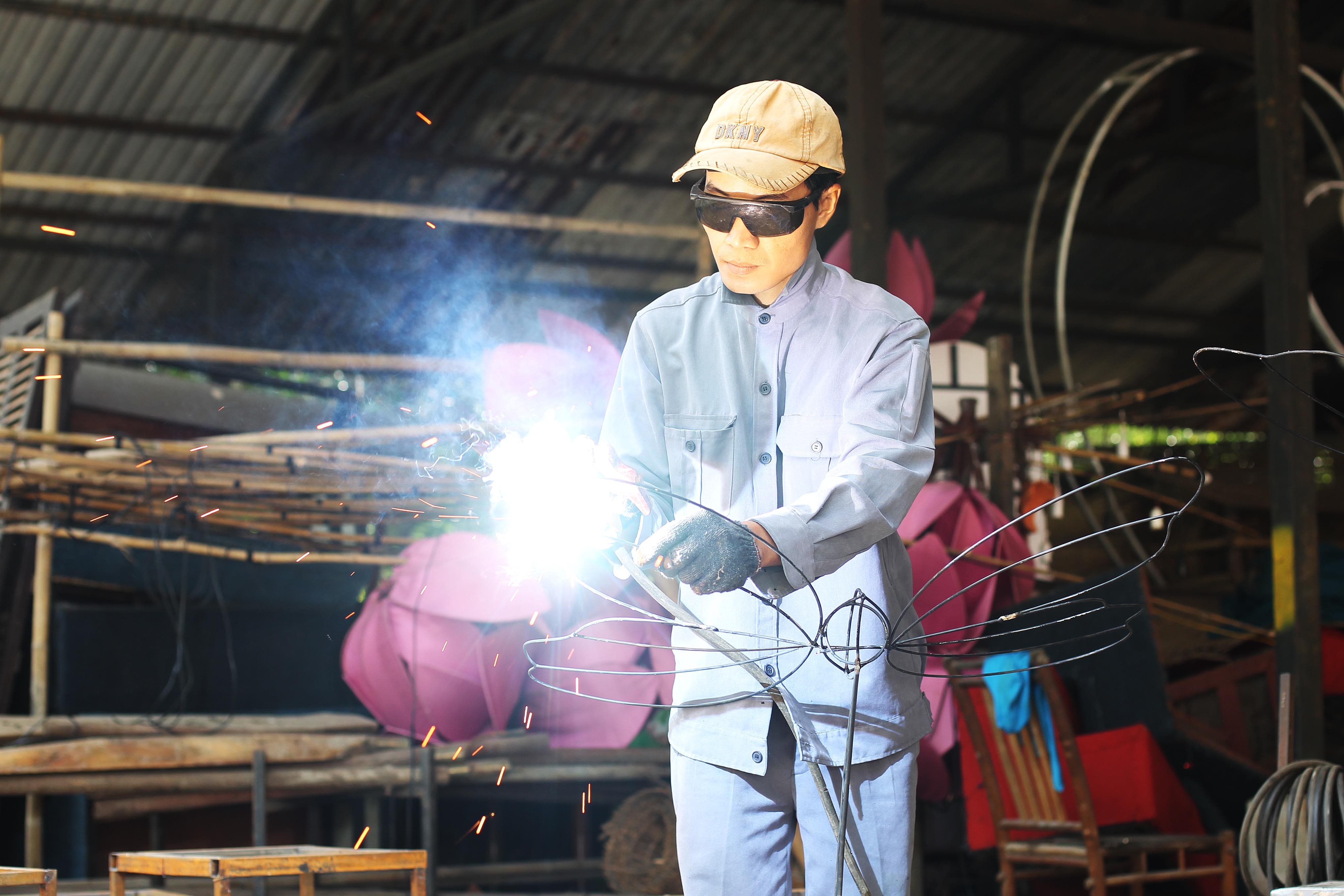 Anh Tài đang hoàn tất phần khung của một tiểu cảnh hình bươm bướm