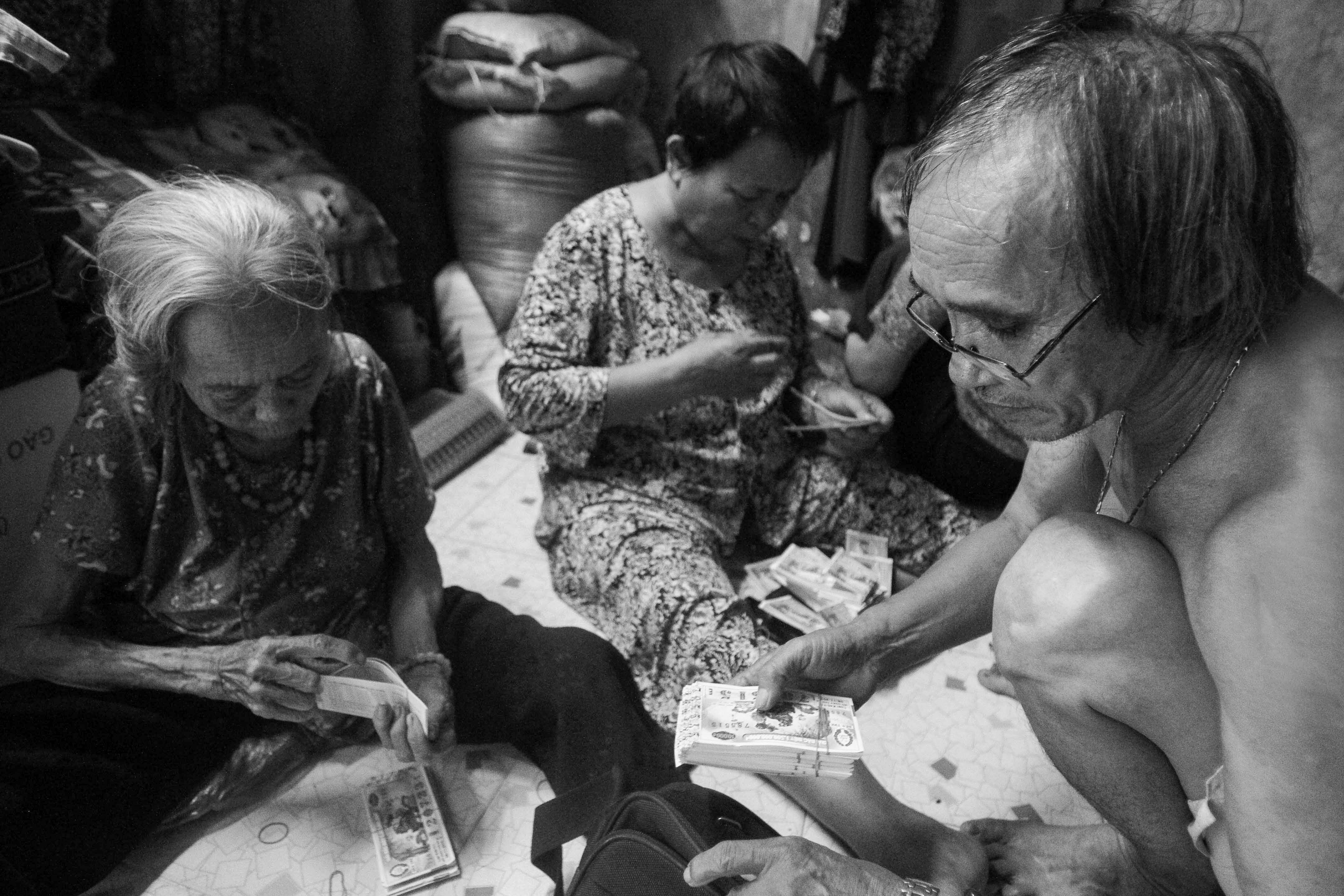 Sau giấc ngủ trưa ngắn ngủi, ông Tiến đến đại lý lấy vé số về chia cho các cụ để chuẩn bị buổi chiều cùng nhau đi bán