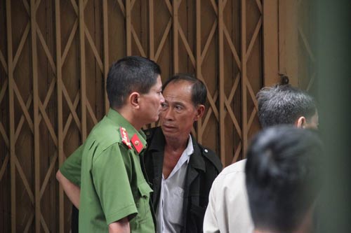 Ông Trung (áo khoác đen) như chết lặng khi biết các con và cháu ngoại đều đã thiệt mạng trong vụ cháy Ảnh: Gia Minh