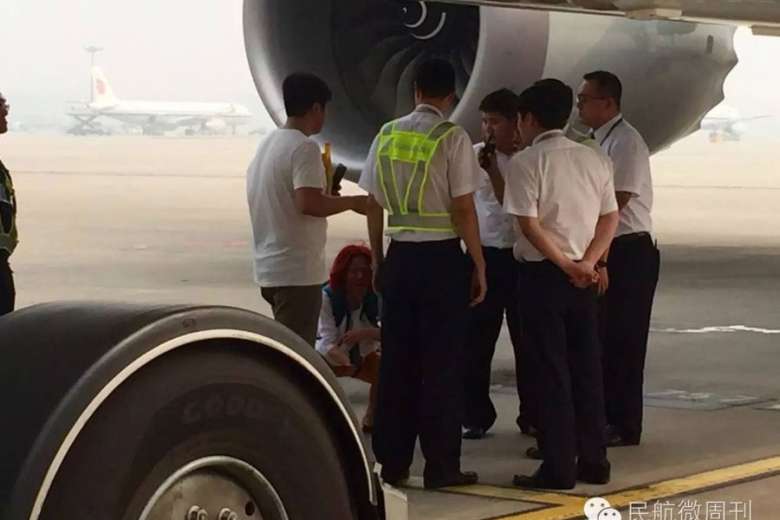 Người phụ nữ ngồi trên đường băng. Ảnh: China Daily