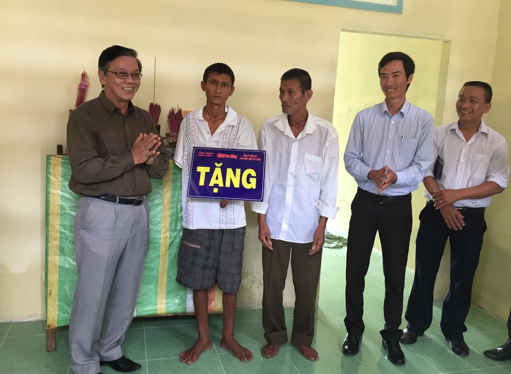 Ông Nguyễn Văn Tín (ngoài cùng bên trái), Phó Tổng Biên tập Báo Người Lao Động bàn giao nhà cho Bé Cụt (thứ 2 từ trái sang)
