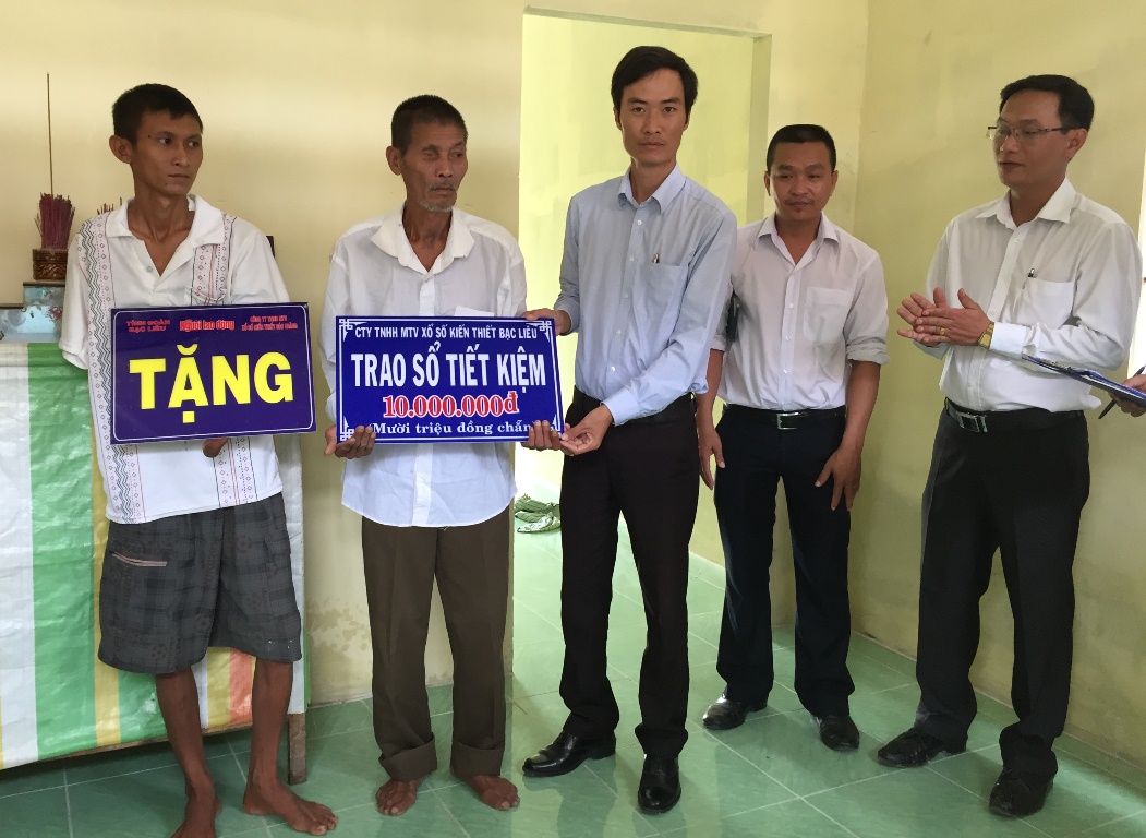 Gia đình Bé Cụt nhận tiền hỗ trợ của Công ty TNHH một thành viên Xổ số kiến thiết Bạc Liêu nhân dịp nhận nhà mới