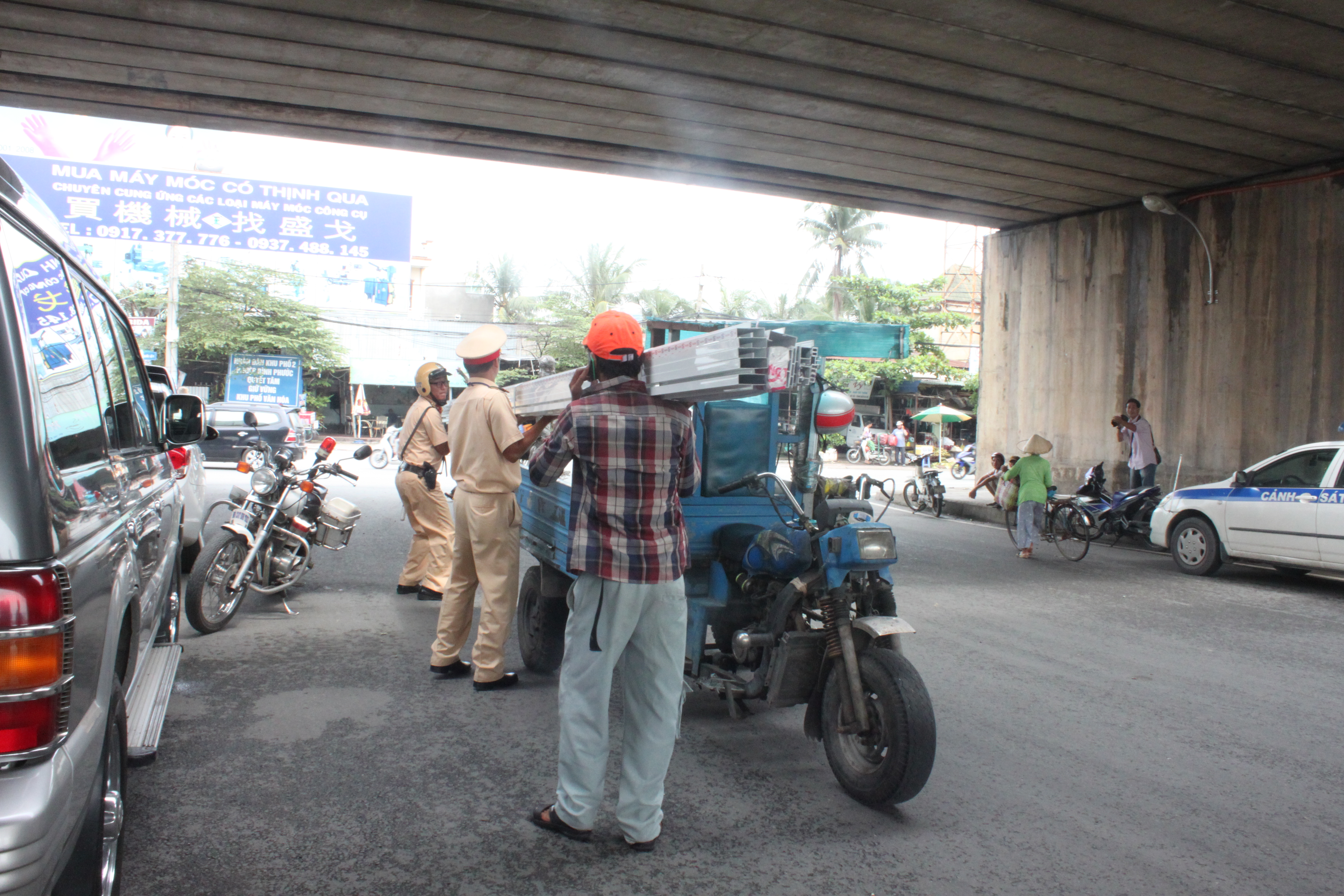 Các chiến sĩ CSGT Bình Triệu đang giúp chủ phương tiện xuống hàng tại chỗ vì chở quá quy định cho phép
