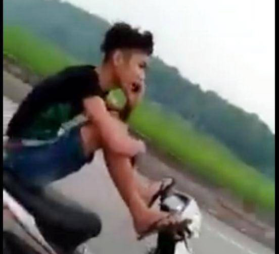 Lái xe máy bằng 2 chân, tay cầm điện thoại gọi “khoe” mẹ
