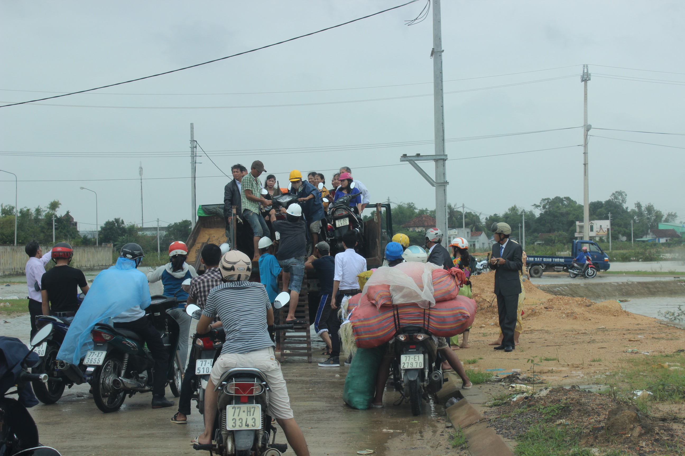 
Người d&acirc;n v&ugrave;ng lũ &ldquo;xếp h&agrave;ng&rdquo; chờ l&ecirc;n xe tải &ldquo;tăng bo&rdquo; qua những đoạn đường ngập nước
