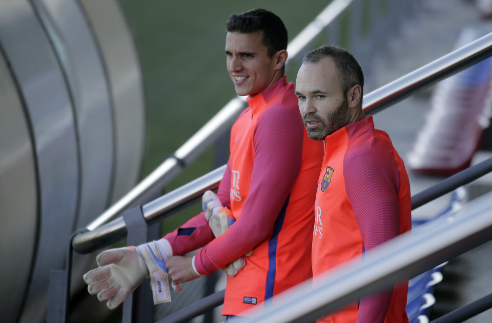 Andres Iniesta, b&ecirc;n phải, v&agrave; thủ m&ocirc;n dự bị Jordi Masip nghỉ ngơi giữa buổi tập h&ocirc;m 2-12
