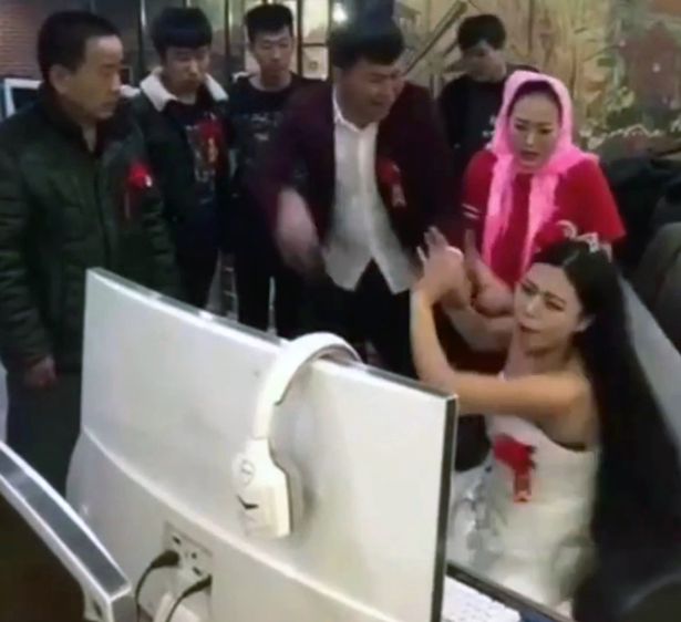
Bất chấp ch&uacute; rể v&agrave; nh&agrave; trai l&ocirc;i k&eacute;o, c&ocirc; d&acirc;u vẫn tiếp tục d&aacute;n mắt v&agrave;o m&agrave;n h&igrave;nh m&aacute;y t&iacute;nh. Ảnh: Mirror
