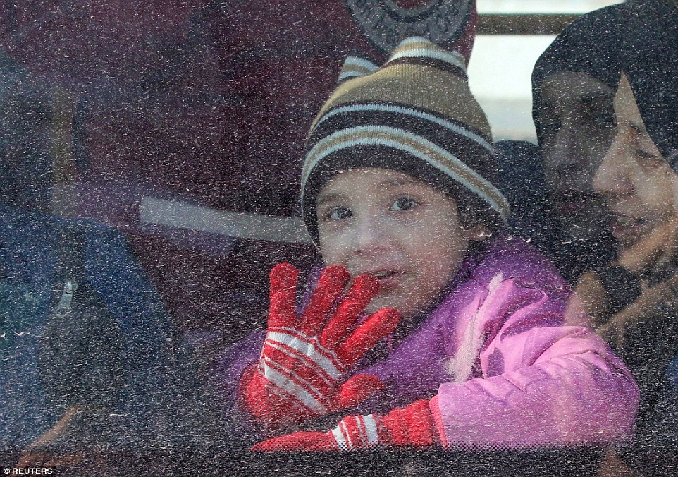 Em bé trên chiếc xe buýt rời khỏi Aleppo. Ảnh: Reuters