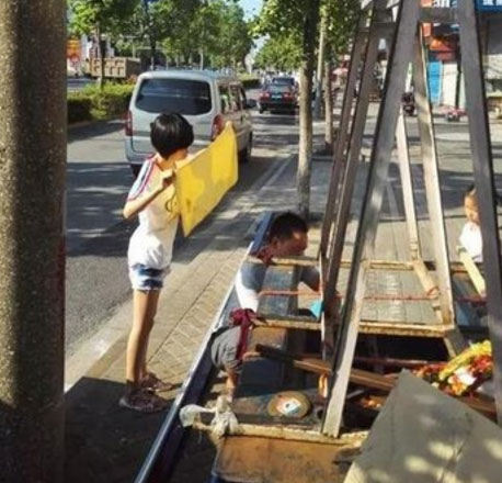 Bức ảnh cô bé lấy khăn che nắng cho bố sửa xe gây xúc động