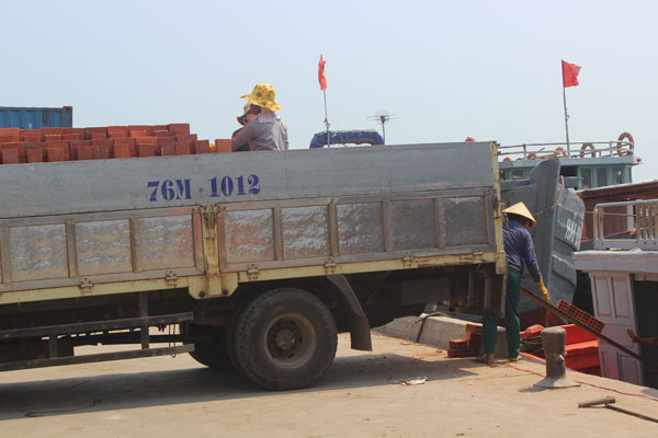 Chiếc xe chở đầy ắp gạch chờ các chị chuyển xuống tàu ra đảo.