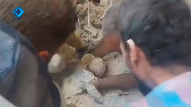 Bé gái 5 tuổi Rawan Alowsh được kéo ra khỏi đống đổ nát. Ảnh: REUTERS