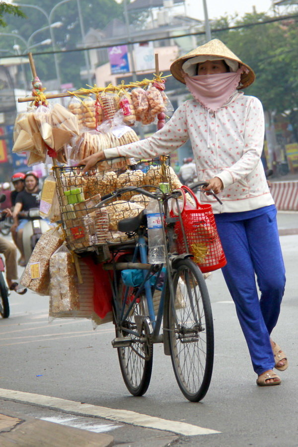 
Chị b&aacute;n b&aacute;nh dạo với xe b&aacute;n c&aacute;c loại b&aacute;nh b&igrave;nh d&acirc;n, trong đ&oacute; c&oacute; b&aacute;nh chao - Ảnh: BẢO KH&Ocirc;I

