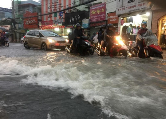 
C&ograve;n tại khu vực quận Thủ Đức, nước chảy như lũ. Trong ảnh l&agrave; tr&ecirc;n đường V&otilde; Văn Ng&acirc;n.
