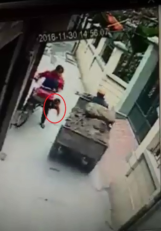 
Khi gặp xe c&ocirc;ng n&ocirc;ng, người phụ nữ bị giật m&igrave;nh v&agrave; loạng choạng khiến b&eacute; trai rơi khỏi xe đạp. Ảnh cắt từ video
