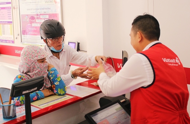 Một cụ gi&agrave; hơn 70 tuổi đến mua v&eacute; tại một điểm b&aacute;n h&agrave;ng tr&ecirc;n đường Trần Ph&uacute;.