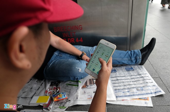 
Một người chơi Pokemon Go trong l&uacute;c chờ đợi. Điện thoại, s&aacute;ch b&aacute;o... l&agrave; những th&uacute; vui &iacute;t ỏi gi&uacute;p những người xếp h&agrave;ng ở đ&acirc;y giết thời gian.
