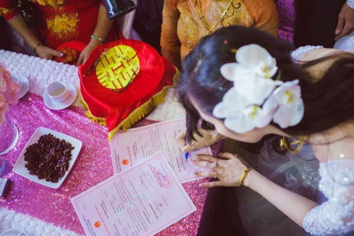 Ký tên vào tờ giấy đăng ký kết hôn.