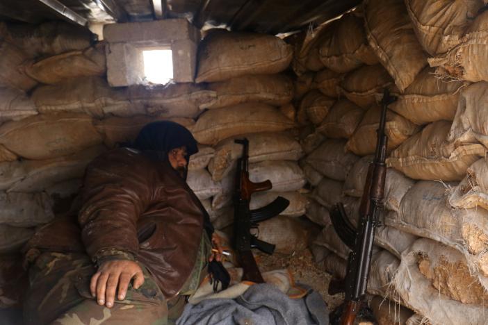 Một tay súng của phiến quân nghỉ ngơi ở khu vực Rashideen, tỉnh Aleppo, Syria hôm 30-12. Ảnh: Reuters