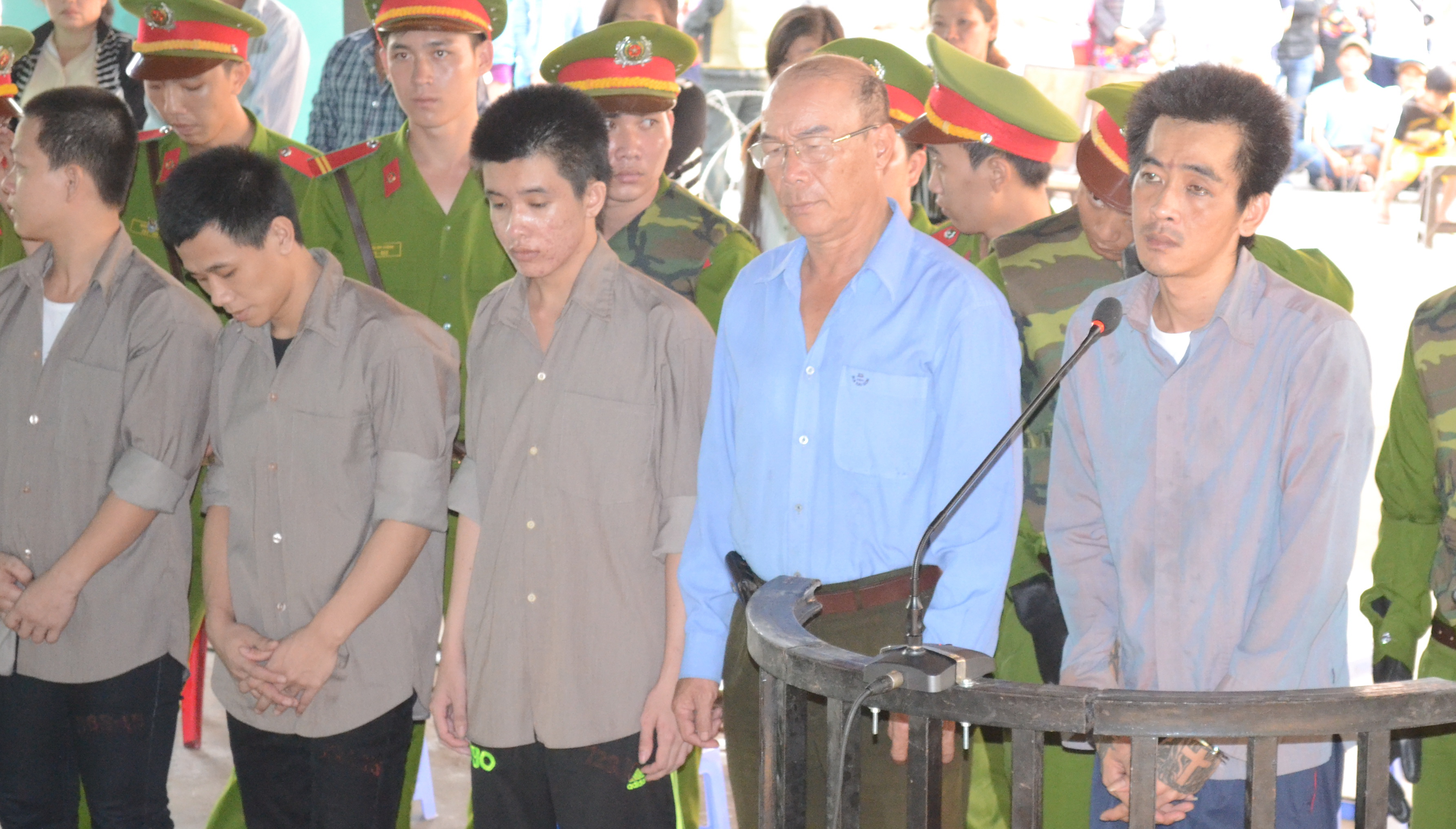 Tuấn Em (đứng bìa phải) cùng bị cáo Chưởng (áo xanh) tại phiên tòa sơ thẩm ngày 24-3 vừa qua.