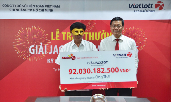 Một người tr&uacute;ng giải xổ số của Vietlott đeo mặt nạ nhận thưởng.
