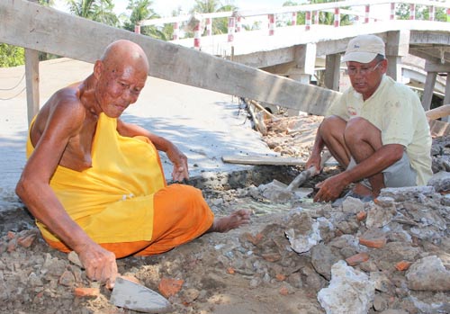 Sư Trần Nhiếp đang phụ c&aacute;c c&ocirc;ng nh&acirc;n thi c&ocirc;ng một c&acirc;y cầu