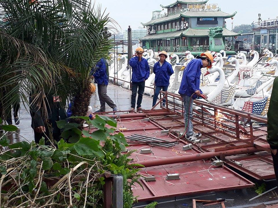 Công nhân đang cắt cầu dẫn ra một nhà nổi khu vực hồ Tây