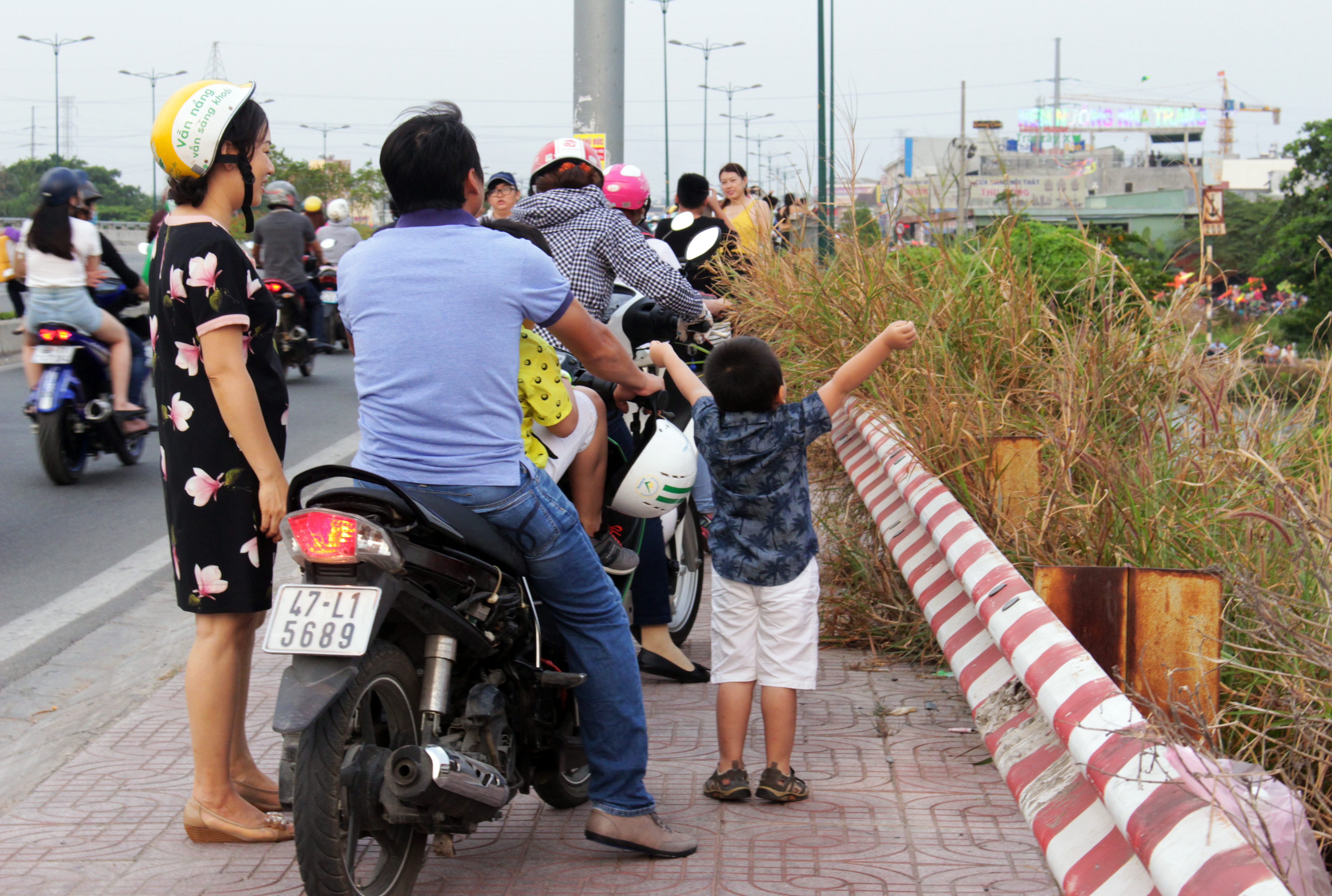 Một cậu bé gọi bố mẹ dừng xe lại, tỏ ra phấn khích khi được ngắm các cánh diều đủ sắc màu bay phấp phới trên bầu trời.