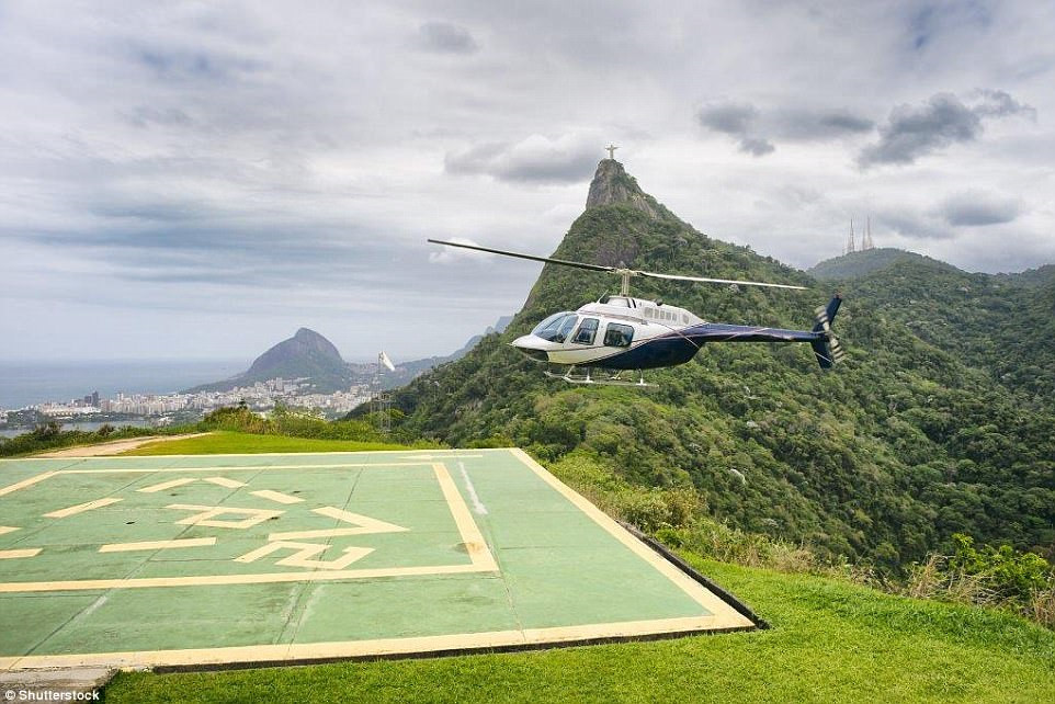 Một trực thăng ngắm cảnh chuẩn bị đáp xuống chân núi Corcovado ở Rio de Janeiro, Brazil. Bạn có thể thấy tượng Chúa Cứu Thế ở phía xa.