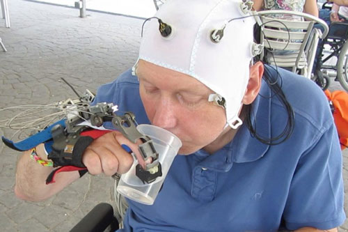Bàn tay robot sinh học được não điều khiển để cầm cốc nước Ảnh: NEW SCIENTIST
