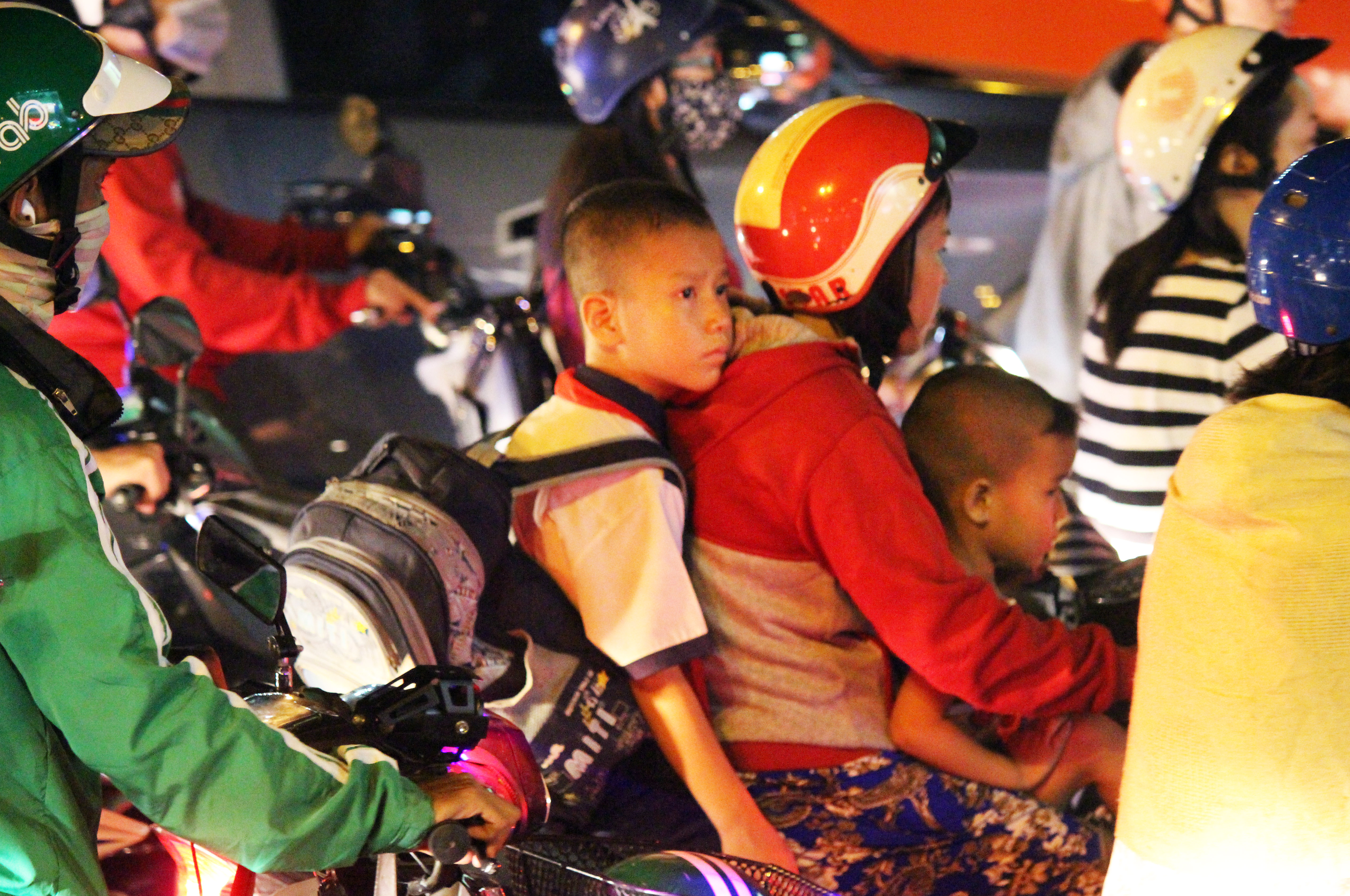 C&aacute;c em nhỏ theo cha mẹ tr&ecirc;n đường đi học về cũng phải mệt mỏi, nhiều em ngủ lu&ocirc;n tr&ecirc;n xe.