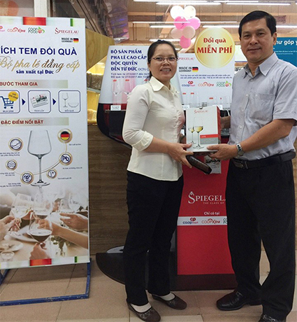 Ông Nguyễn Hữu Đại - Giám đốc Co.opmart Nguyễn Kiệm trao tặng bộ ly vang đỏ cao cấp cho khách