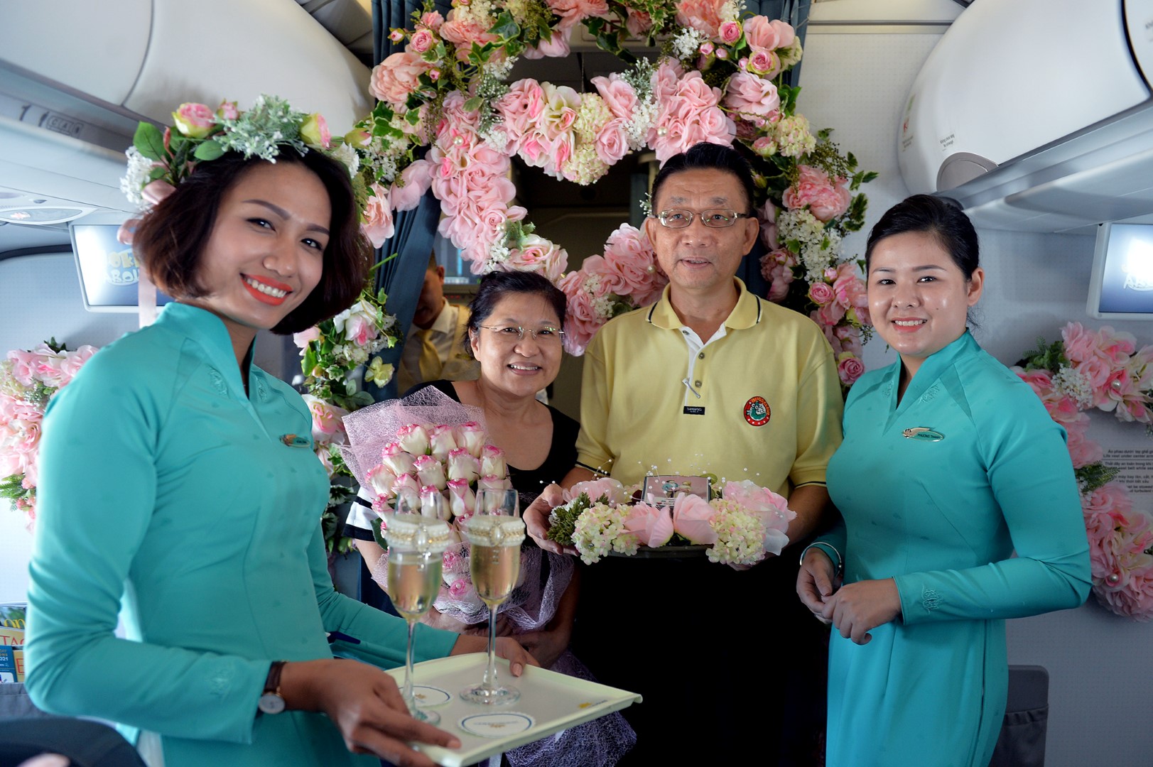 
C&aacute;c tiếp vi&ecirc;n mang rượu champagne v&agrave; b&aacute;nh để ch&uacute;c mừng đ&ocirc;i vợ chồng
