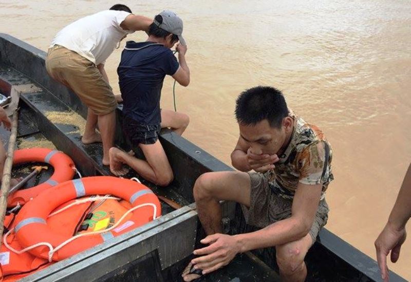 Bộ đội cứu 2 bố con đang đu d&acirc;y điện giữa d&ograve;ng nước lũ - Ảnh 2.