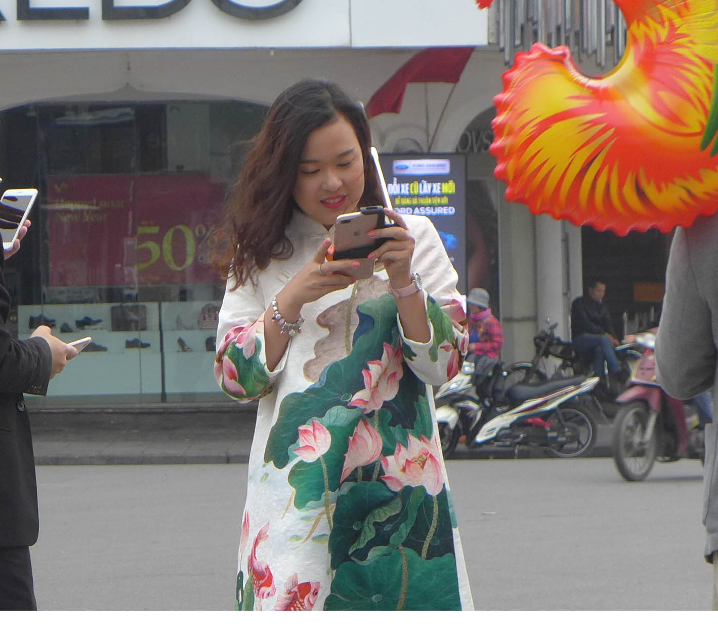 Một cô gái xinh đẹp với tà áo dài độc đáo trước đài phun nước hồ Gươm