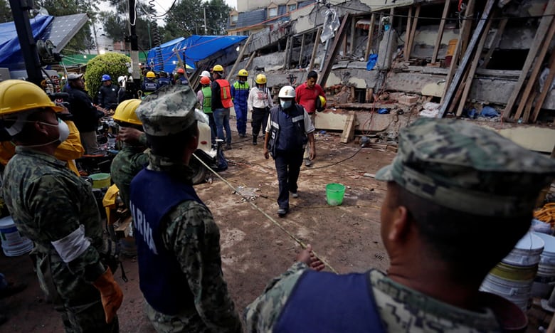 Các nhân viên cứu hộ tìm kiếm nạn nhân ở trường Enrique Rebsamen. Ảnh: Reuters