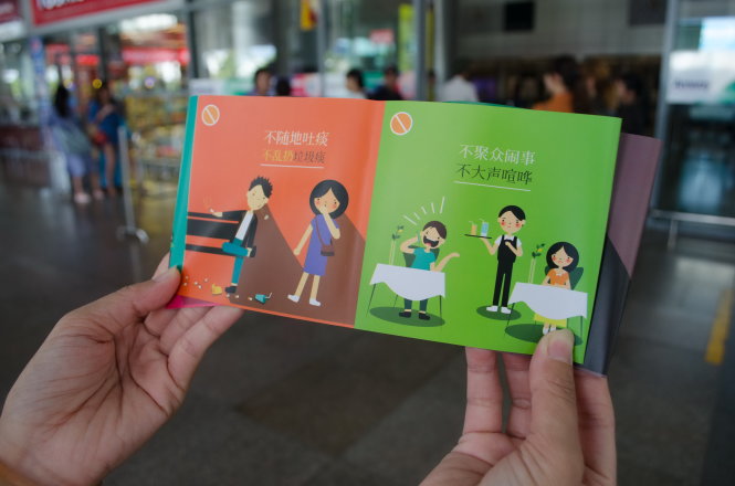 Trước đây Đà Nẵng đã ban hành bộ quy tắc ứng xử cho khách nước ngoài. Trong ảnh: phát bộ quy tắc ứng xử bằng tiếng Trung Quốc (ảnh dưới) cho du khách tại sân bay Đà Nẵng - Ảnh: TẤN LỰC