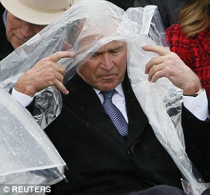 Ban đầu, ông Bush trùm áo mưa lên đầu. Ảnh: Reuters