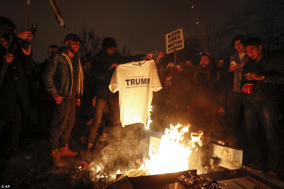 
Một nh&oacute;m đốt &aacute;o &ocirc;ng Trump. Ảnh: AP
