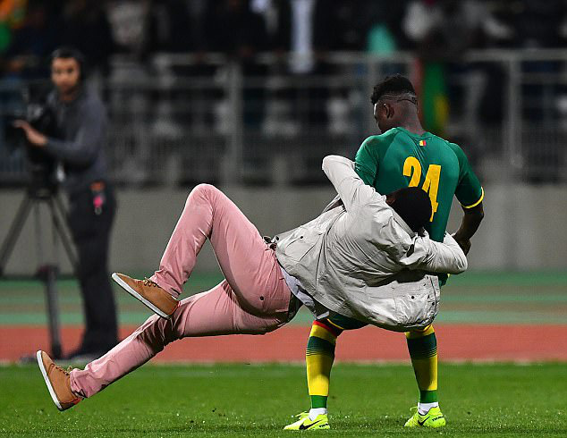 Lamine Gassama (Senegal) bị một fan cuồng ôm lấy