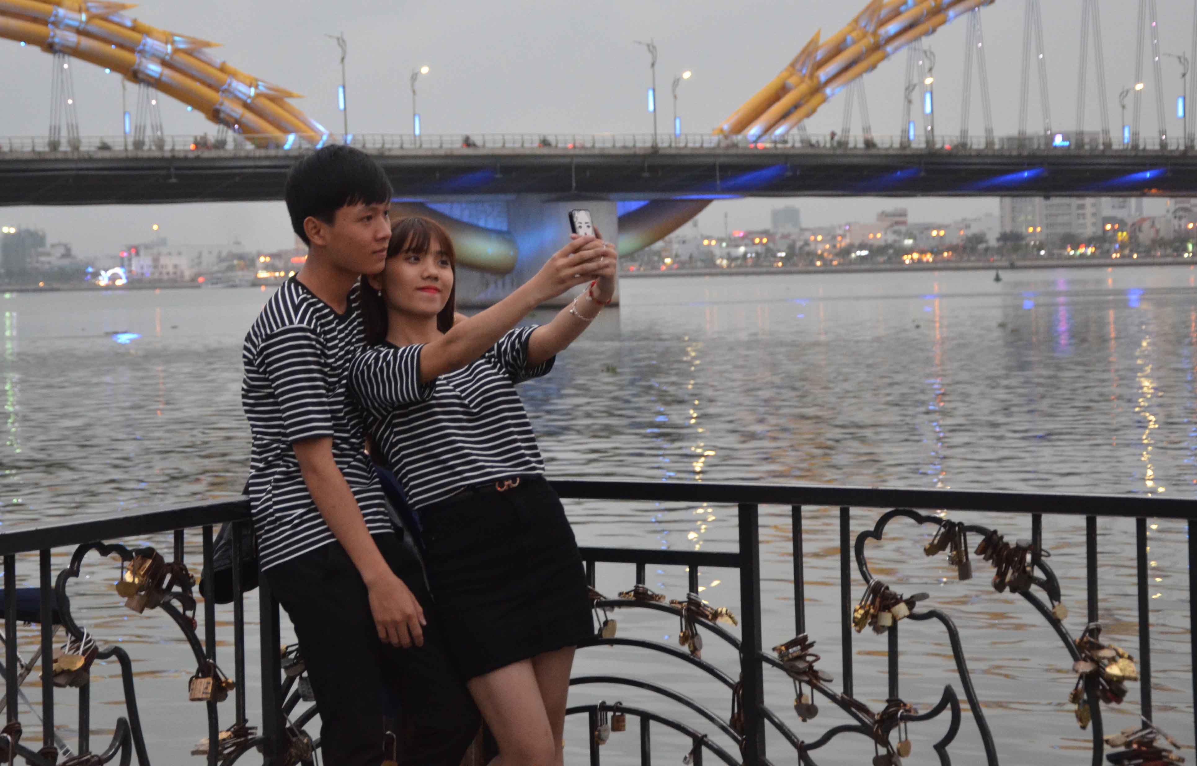 
Cặp đ&ocirc;i n&agrave;y tranh thủ chụp ảnh lưu niệm lại tr&ecirc;n cầu t&agrave;u t&igrave;nh y&ecirc;u để giữ khoảnh khắc đẹp trong ng&agrave;y lễ t&igrave;nh nh&acirc;n
