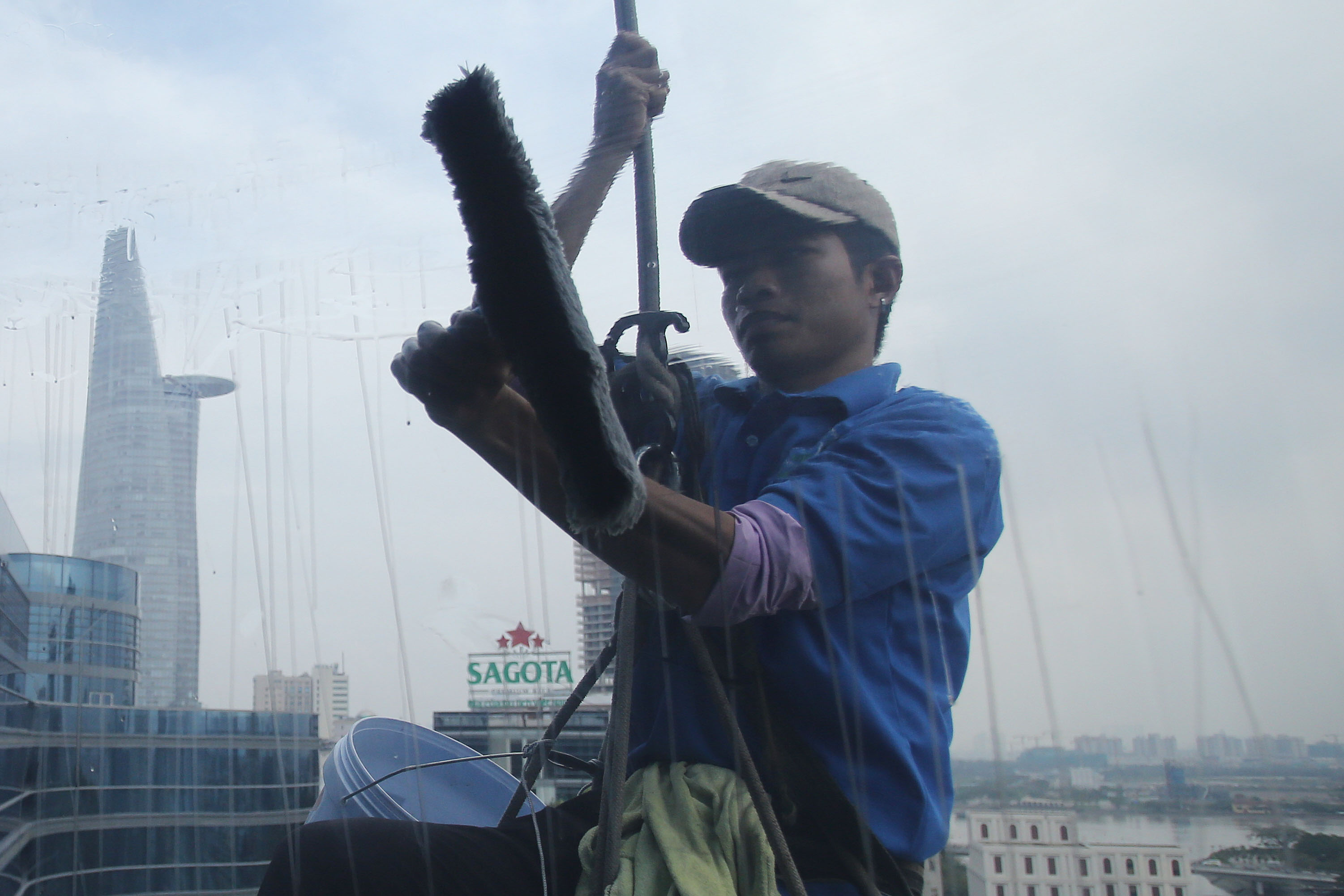 Một người thợ đang lau vết loang lổ của tấm kính.
