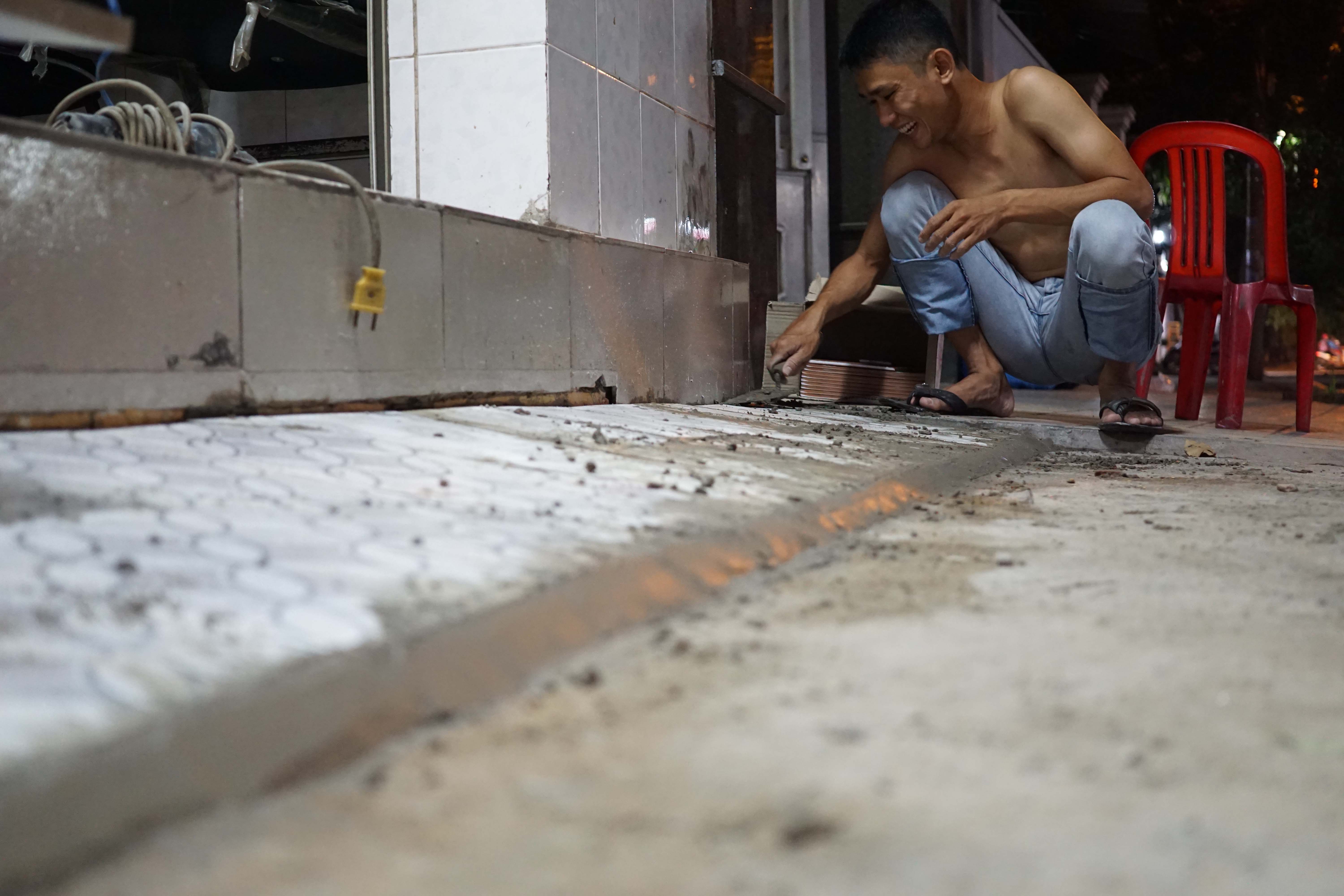 22 giờ 30 phút, ông Lê Quốc Hùng (60 tuổi, ngụ tại số 6, đường Hàn Thuyên, phường Bình Thọ, quận Thủ Đức) vẫn còn xây lại bậc thềm phía trước nhà cho phù hợp sau khi tự giác đập bậc thềm lấn ra vỉa hè trước nhà.